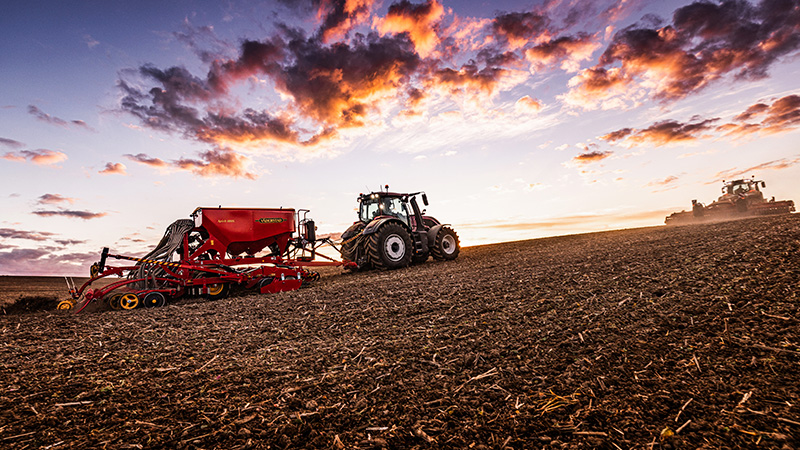 Traktor Valtra serii Q z doczepioną maszyną rolniczą, wykonujący prace na polu 