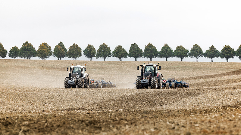 Dwa traktory Valtra w trakcie prac w polu